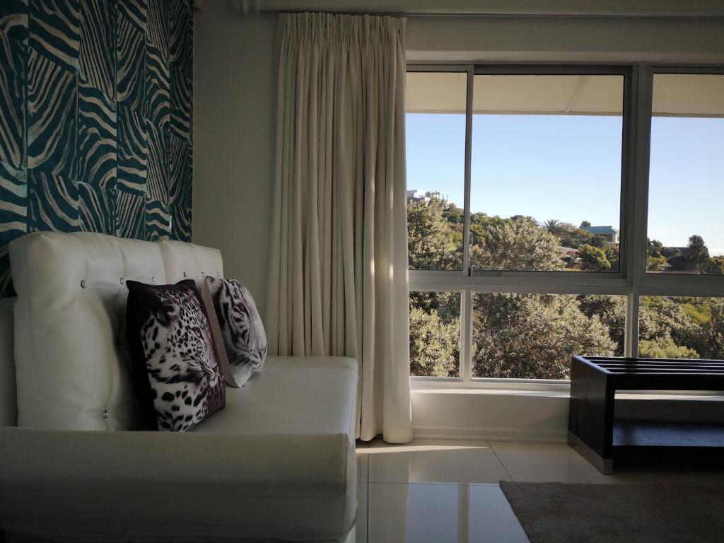 a living room with a couch and two windows at Diamond House Guesthouse in Cape Town