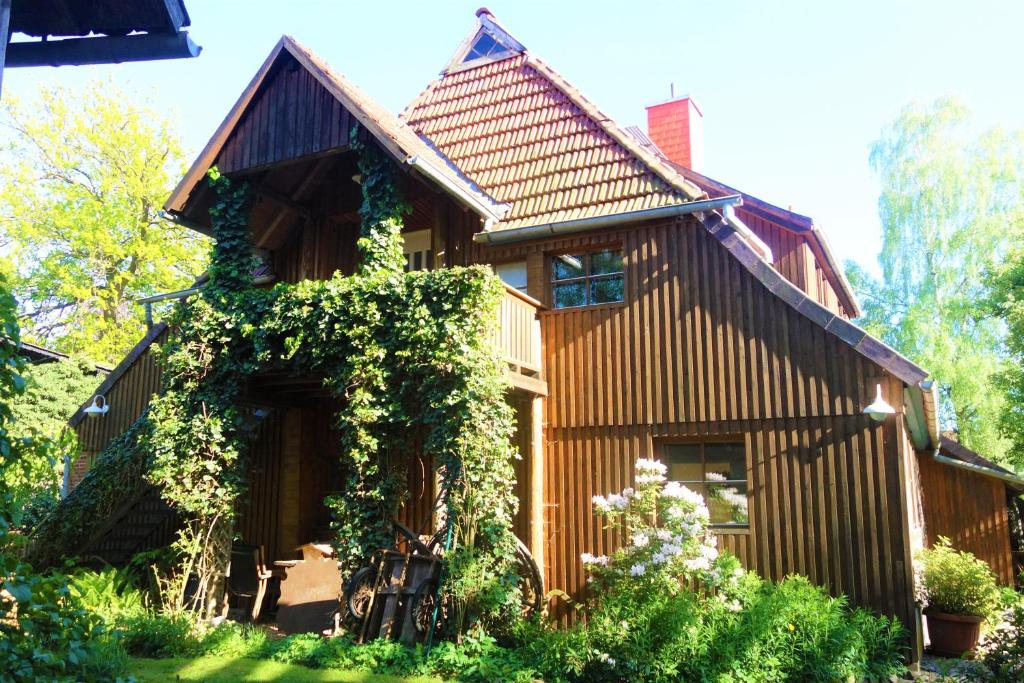 a wooden house with ivy on the side of it at FeWo Spitzweg, Garlstorf - Lüneburger Heide in Garlstorf