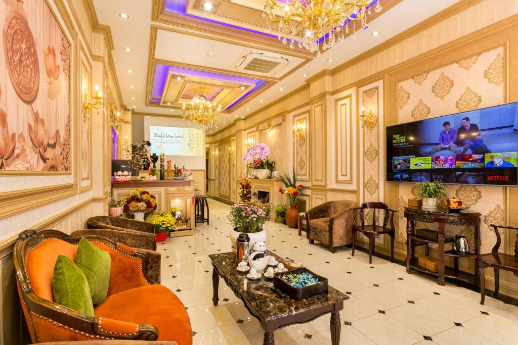 eine Lobby mit Sofas und Stühlen sowie einem TV in der Unterkunft Indochine Ben Thanh Hotel & Apartments in Ho-Chi-Minh-Stadt