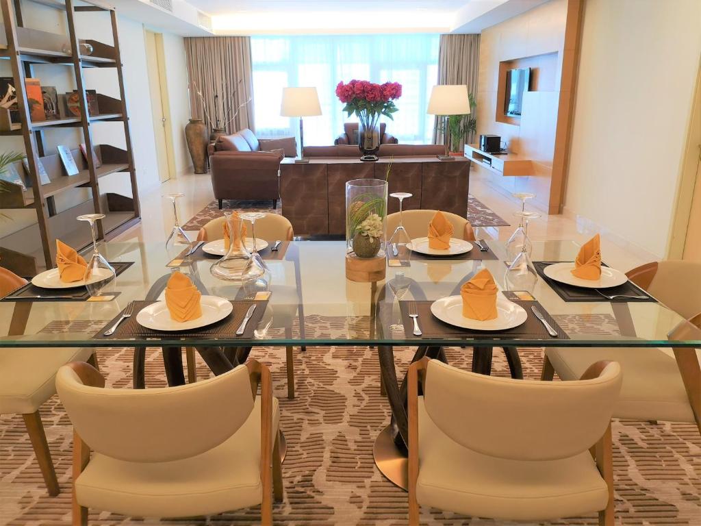 a dining room with a glass table and chairs at Cormar Suites in Kuala Lumpur