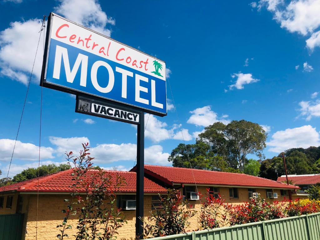 una señal para un motel frente a un edificio en Central Coast Motel, en Wyong