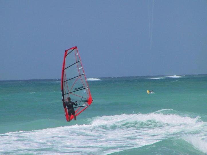 Un uomo sta facendo windsurf nell'oceano di Ocean Bliss Apartments a Christ Church