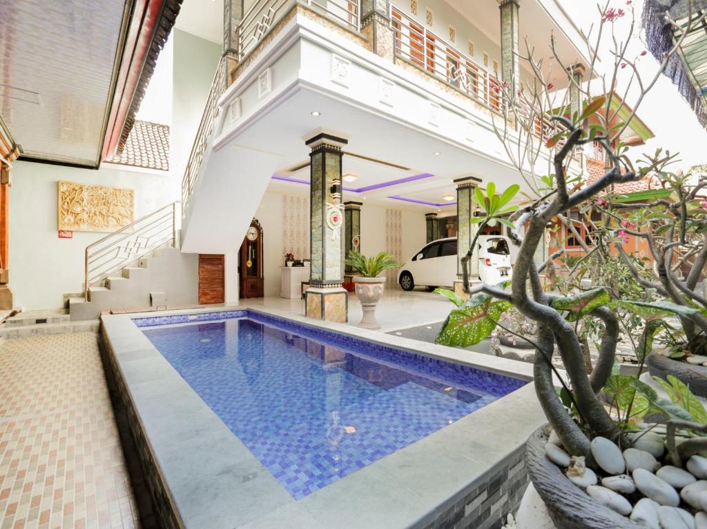 a villa with a swimming pool and a house at OYO 4003 Ceria Guesthouse Seminyak in Seminyak