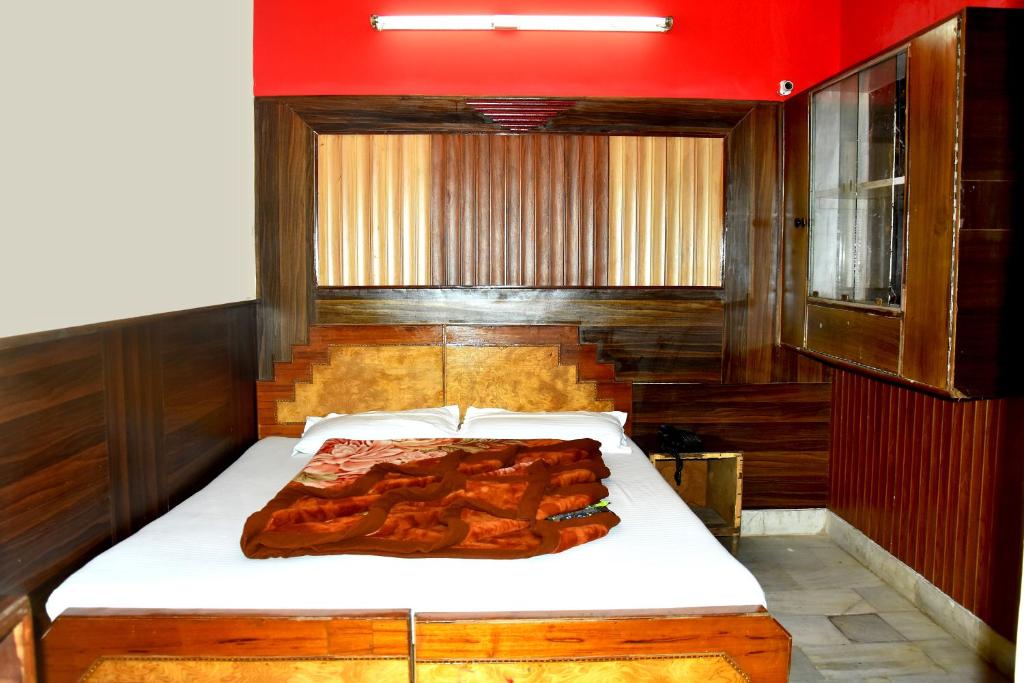 uma cama num quarto com uma parede vermelha em Mother Palace em Nova Deli
