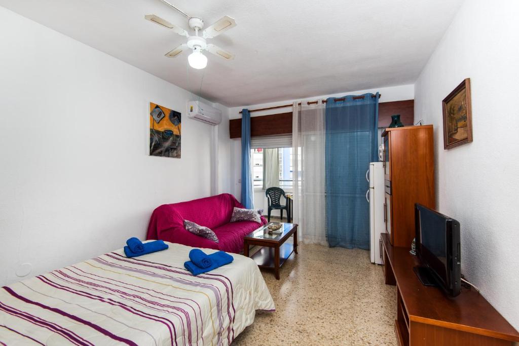 una camera con letto, TV e sedia di Apartamento Pino Torremolinos a Torremolinos