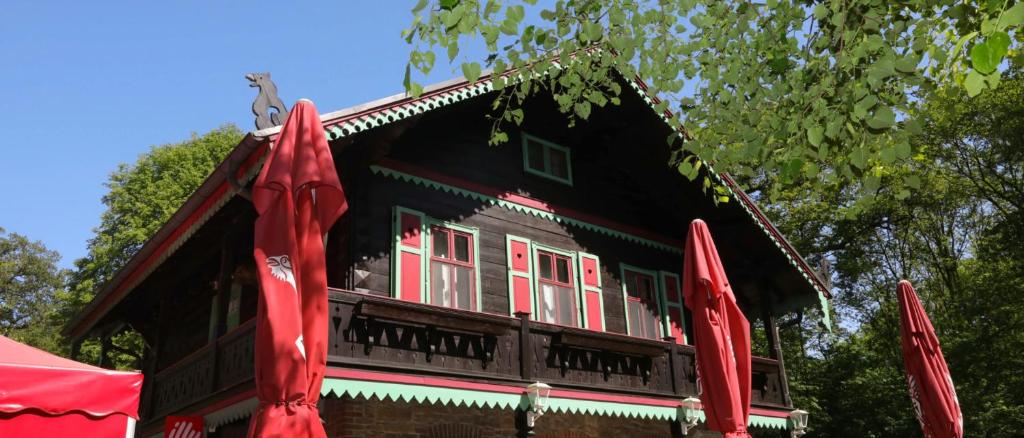 a house with red umbrellas in front of it at Forsthaus Leiner Berg in Dessau