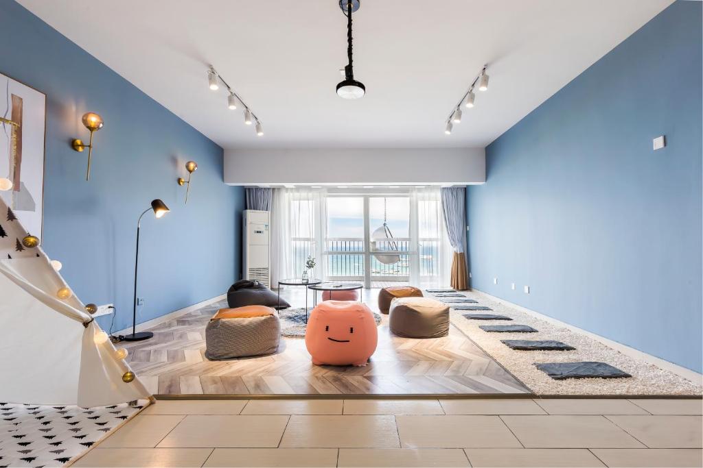 a living room with blue walls and pillows on the floor at Sanya Sun Seaview Apartment in Sanya