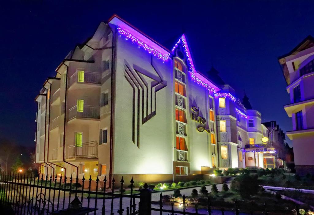 un edificio con luci viola sopra la notte di VICTOR Hotel Resort & SPA a Truskavec'