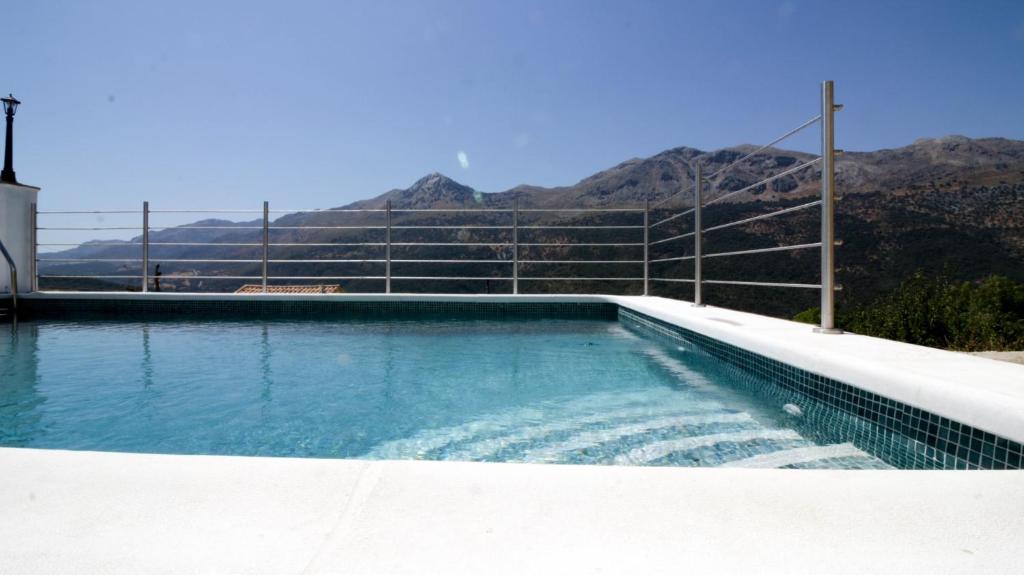 una piscina con montañas en el fondo en El Molino del Panadero, en Jimera de Líbar