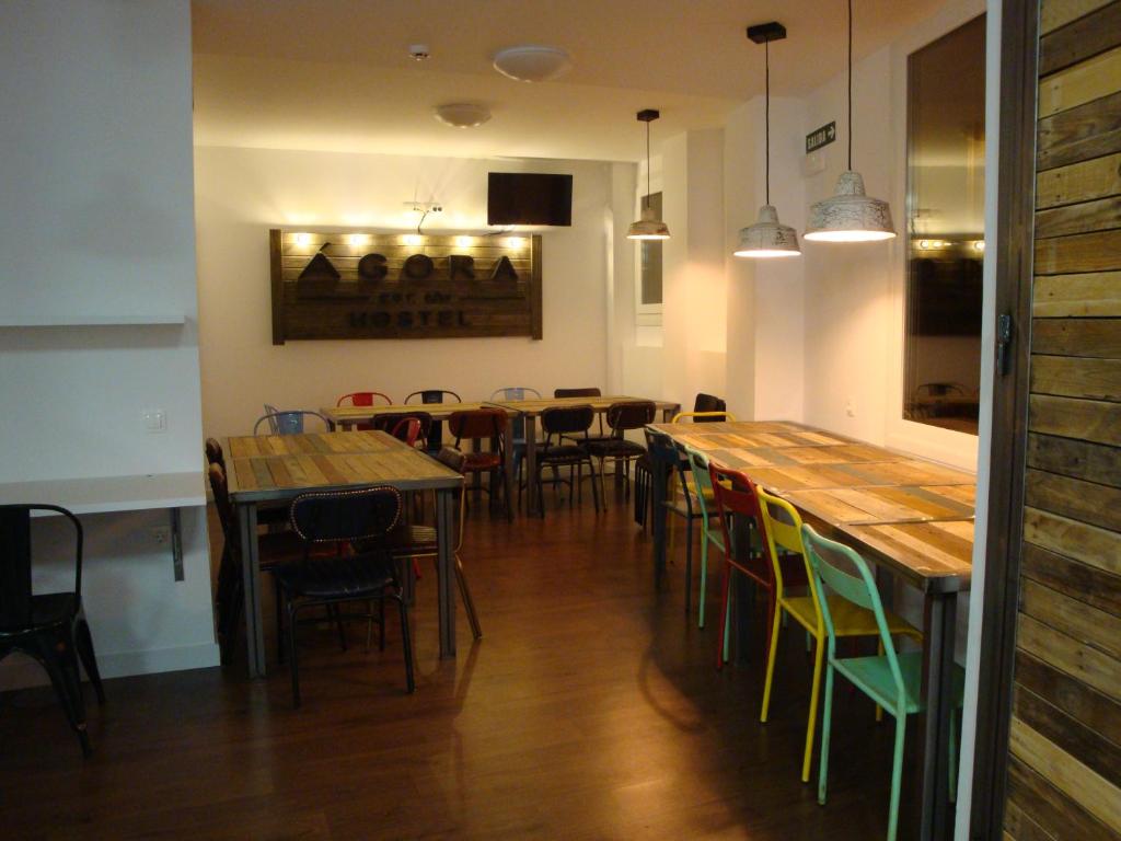 een eetkamer met houten tafels en stoelen bij Agora Hostel in Estella