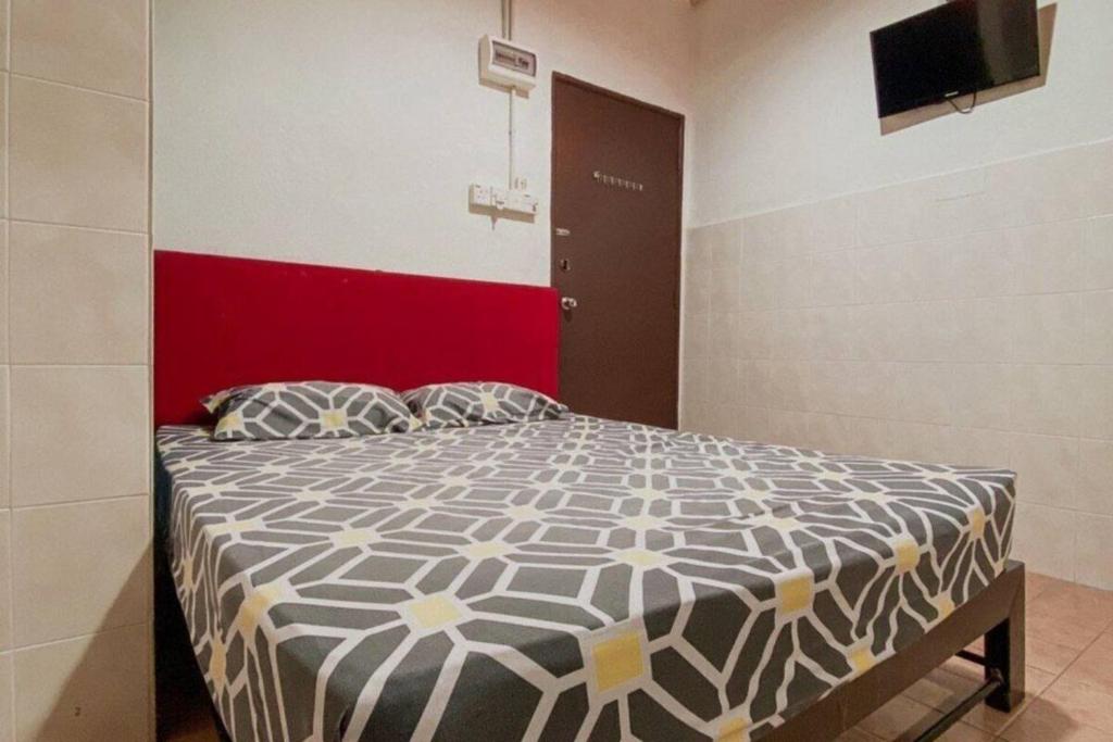 Schlafzimmer mit einem Bett mit einer schwarzen und weißen Bettdecke in der Unterkunft SK Budget Hotel in Jelutong