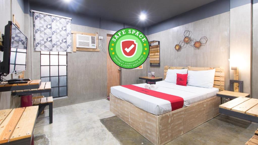 ein Schlafzimmer mit einem Bett und einem Schild an der Wand in der Unterkunft RedDoorz Plus @ Taft North Mandurriao in Iloilo City