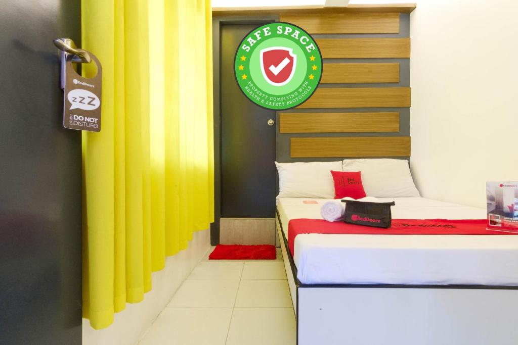 Cette chambre dispose de 2 lits et d'un panneau mural. dans l'établissement RedDoorz near Fishermall Quezon City, à Manille