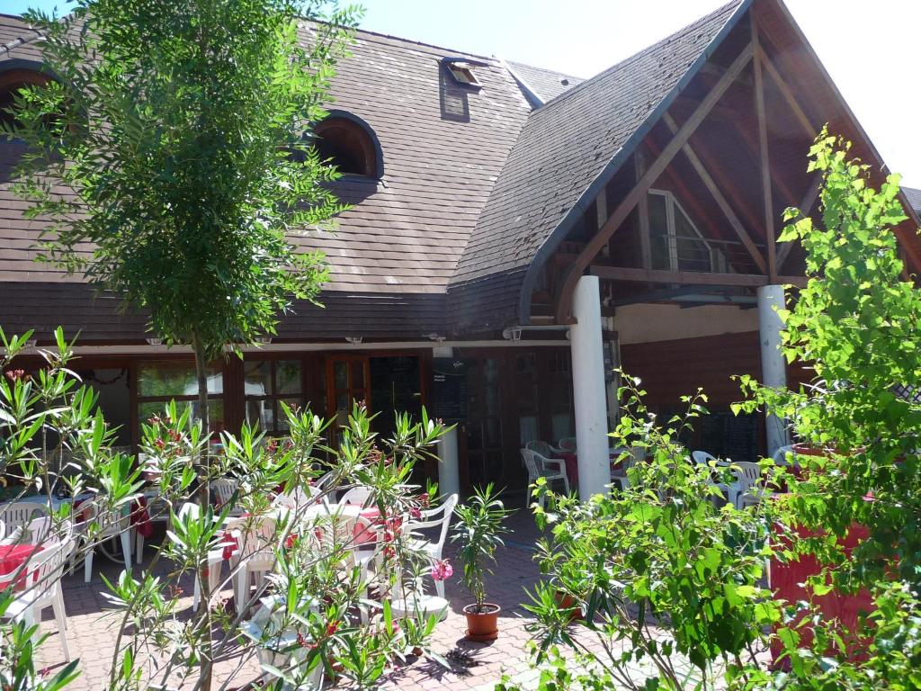 uma casa com muitas plantas à frente dela em Oleander B&B em Siófok