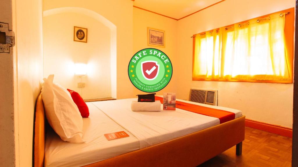 a bedroom with a bed with a green sign on it at RedDoorz near East Avenue Medical Center in Manila