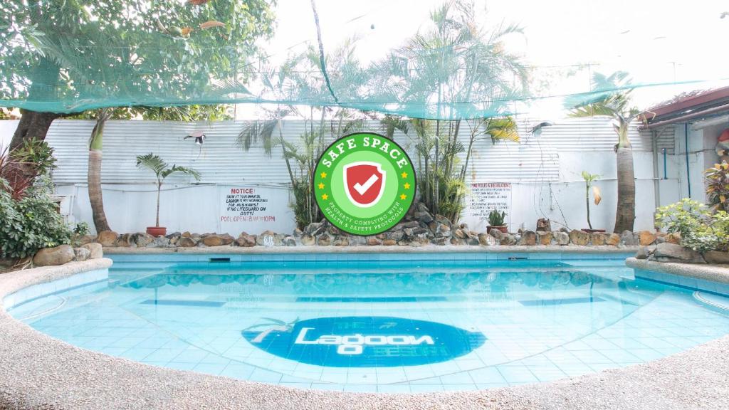 ein Pool in einem Hotel mit Schild drauf in der Unterkunft RedDoorz Plus Lagoon Resort Zambales in Olongapo