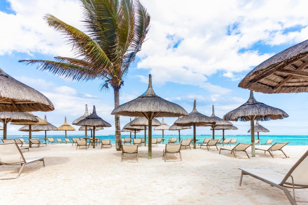 a beach with chairs and umbrellas and the ocean at Friday Attitude in Trou d'Eau Douce