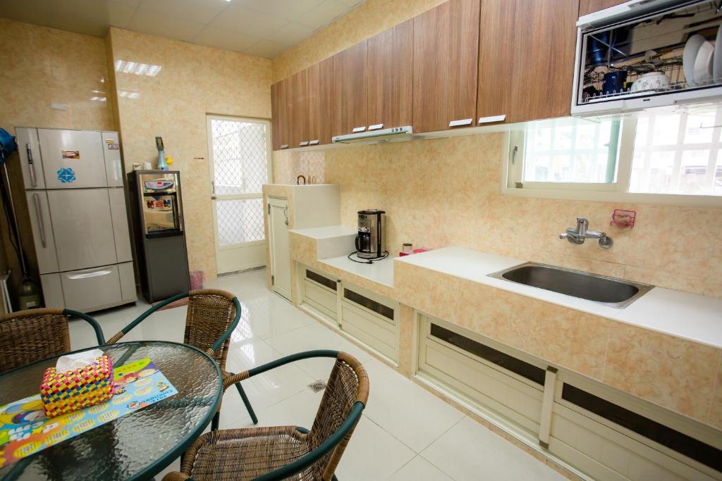 a kitchen with a table and a sink and a refrigerator at Guanshan Fukuda Homestay in Guanshan