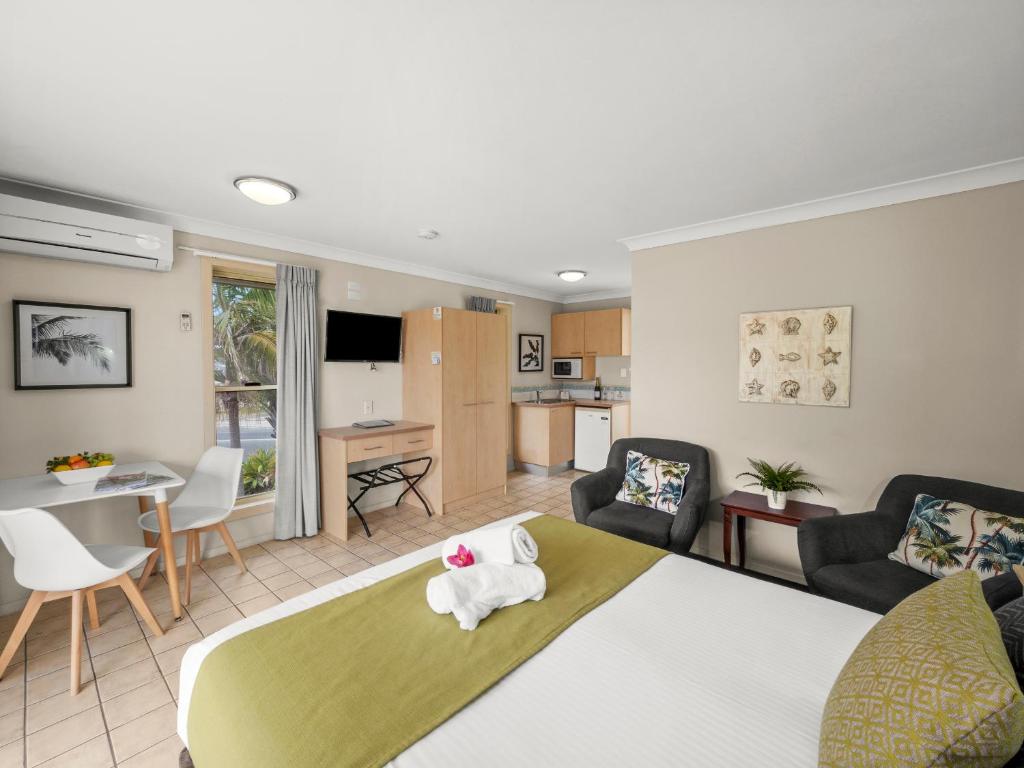 a bedroom with a bed and a living room at Yamba Sun Motel in Yamba