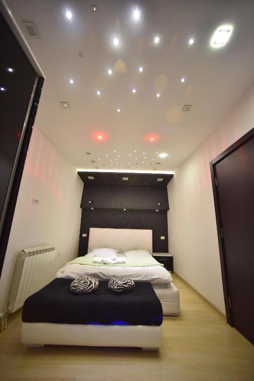a bedroom with a bed with a black and white headboard at Apartman Grk 5 in Zlatibor