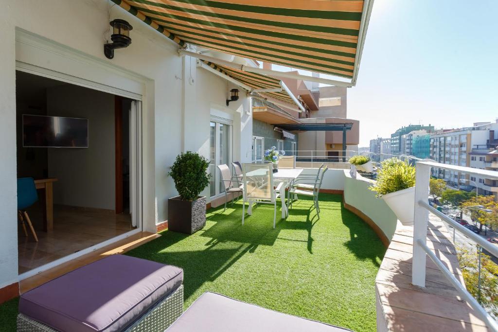 a balcony with green grass and a table and chairs at Atico La JOYITA free parking by Cadiz4Rentals in Cádiz
