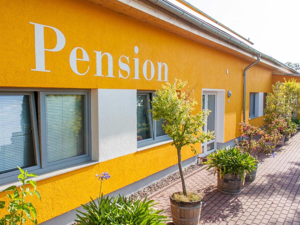 ein gelbes Gebäude mit einem Schild an der Seite in der Unterkunft Pension Molsdorf in Erfurt