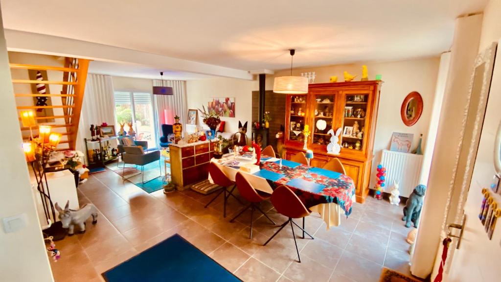 uma sala de estar com uma mesa e uma sala de jantar em Côté Sud em Vern-sur-Seiche