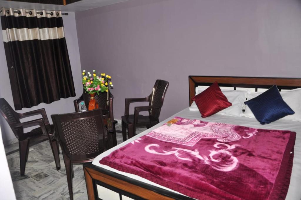 Un dormitorio con una cama con una manta morada. en Green Hill, en Mount Abu