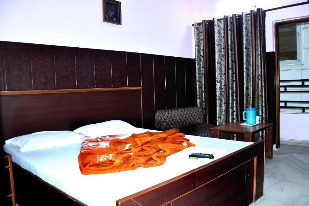 um quarto com uma cama com uma cabeceira de madeira em Mother Palace em Nova Deli
