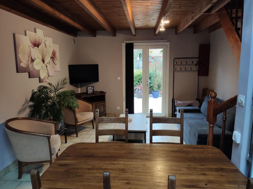 ein Wohnzimmer mit einem Tisch und Stühlen in der Unterkunft Maison proche plage avec terrasse ensoleillée in Dunkerque