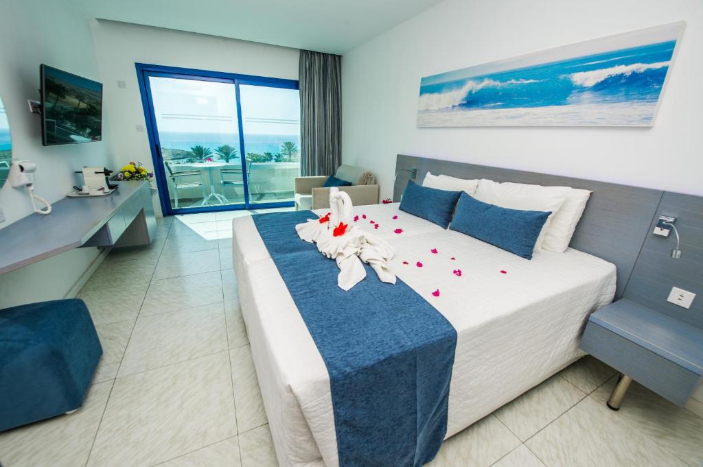 a bedroom with a large bed with red flowers on it at Anonymous Beach Hotel (Adults 16+) in Ayia Napa