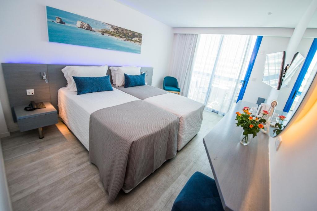 a hotel room with two beds and a table at Anonymous Beach Hotel (Adults 16+) in Ayia Napa
