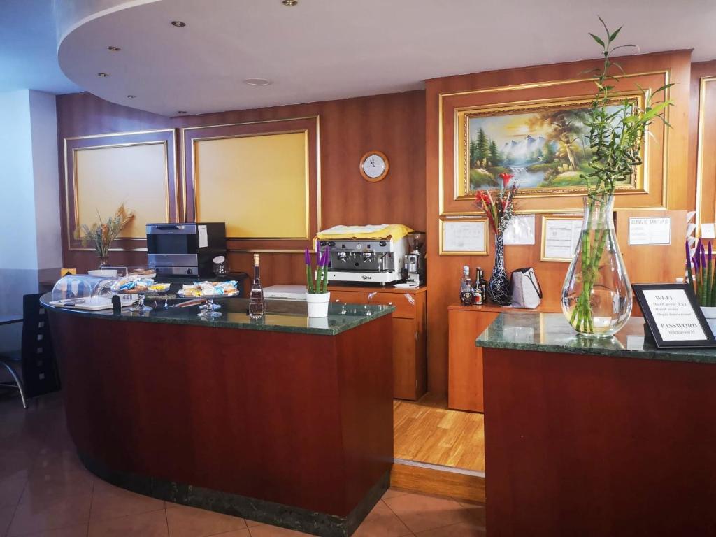 Hotel Cavour Resort في مونكالييري: لوبي مع مكتب استقبال مع مزهرية