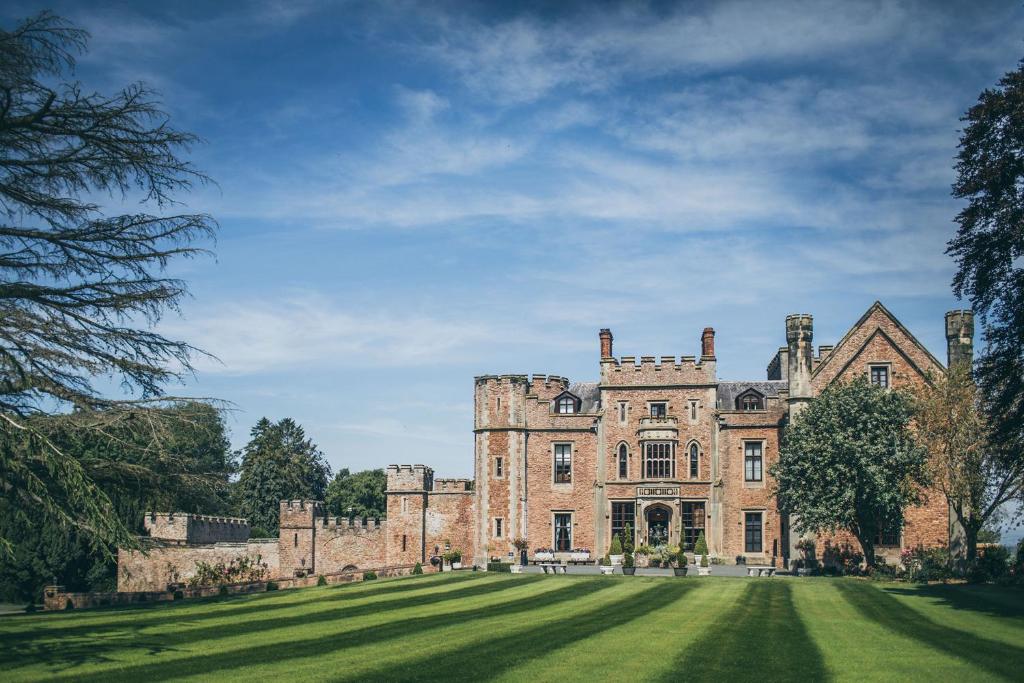 un viejo castillo con un campo de hierba delante de él en Rowton Castle en Shrewsbury