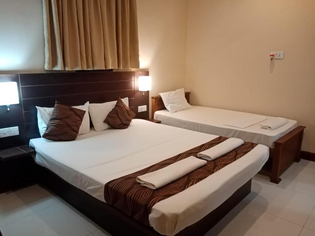 two beds in a hotel room with two bedsvisor at MercuryFM 101 Yarl Mercury Inn - Jaffna in Jaffna
