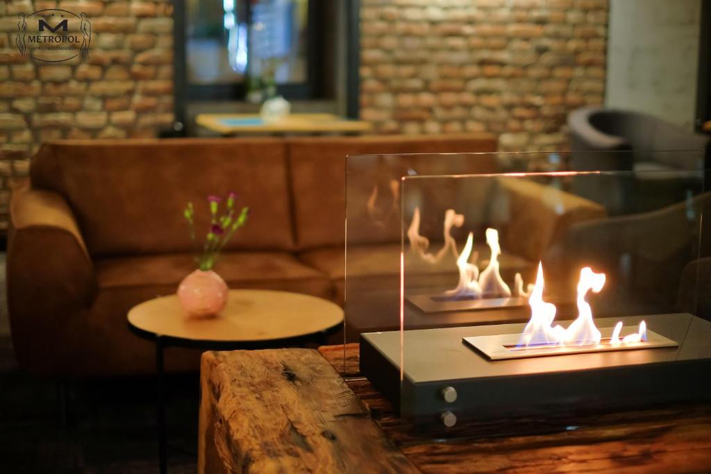 a fireplace in a room with a couch and a table at Metropol in Śrem