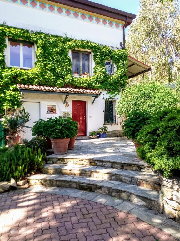 Hotel Cà De Rossana Bed&Breakfast, a house with a red door and a stone walkway at Cà De Rossana Bed&Breakfast in Sanremo