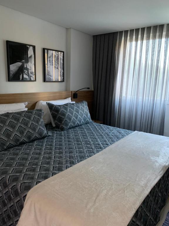 a hotel room with a bed and a window at Flat Manacas Granja Brasil Itaipava in Itaipava