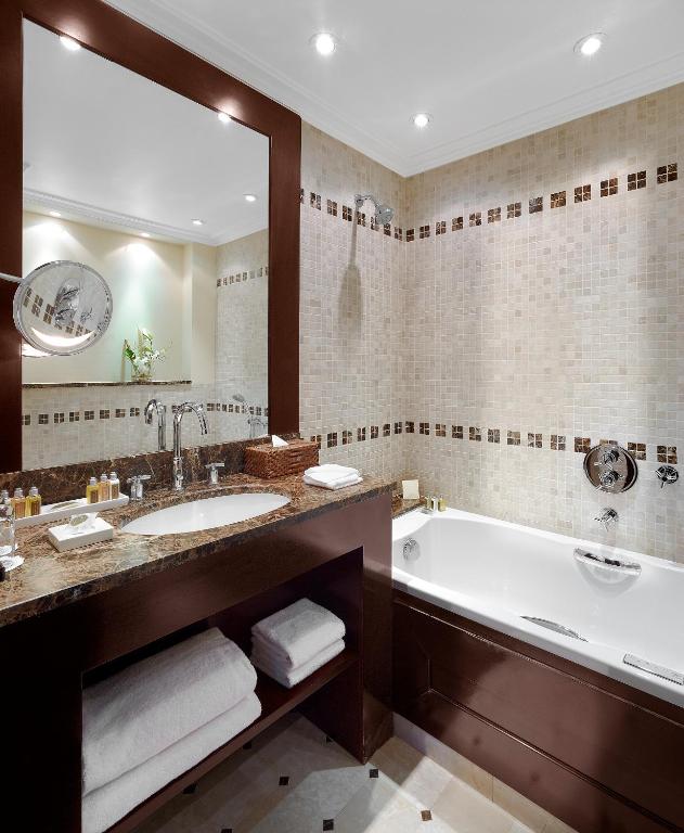 a bathroom with a tub and a large mirror at Hôtel Juana in Juan-les-Pins