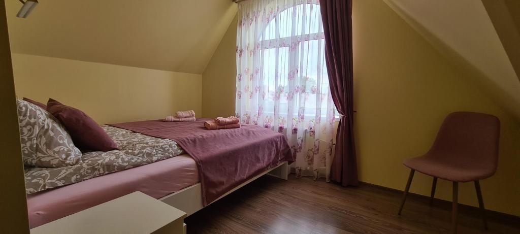 niewielka sypialnia z łóżkiem i oknem w obiekcie Sauliaus apartamentai VIP w Poniewieżu