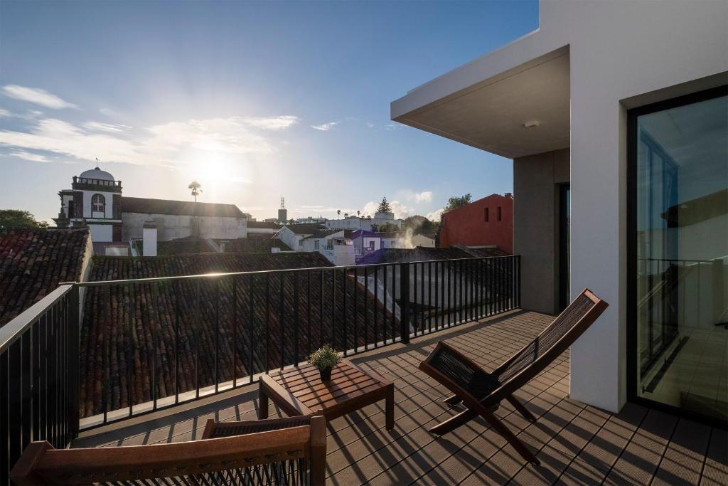 a balcony with two benches and a view of a city at Magma Hostel in Ponta Delgada