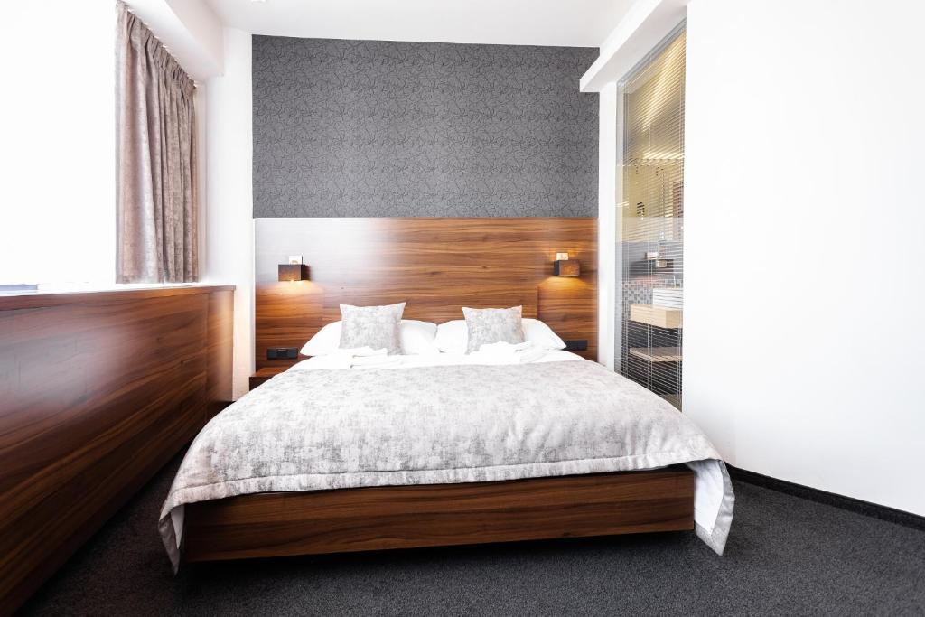Postel nebo postele na pokoji v ubytování Tempus Club Garni Hotel