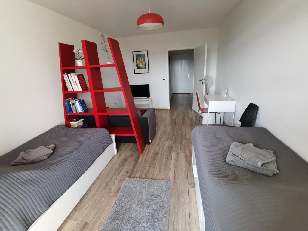ハノーファーにある1-Zimmer Appartement in Hannover/Bemerodeのベッド2台と赤い棚が備わる部屋