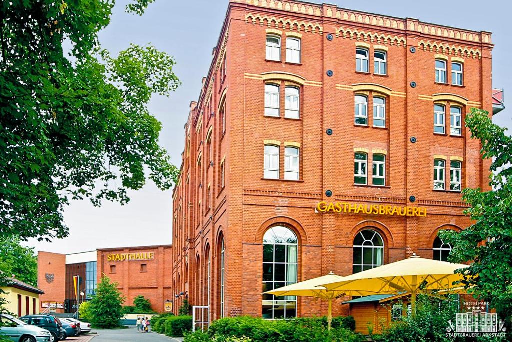 un edificio de ladrillo rojo con un cartel. en Hotelpark Stadtbrauerei Arnstadt, en Arnstadt