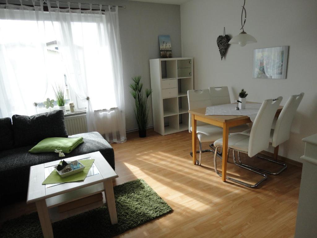 a living room with a couch and a table and chairs at Haus Sandra Ferienwohnung 2 in Dahme