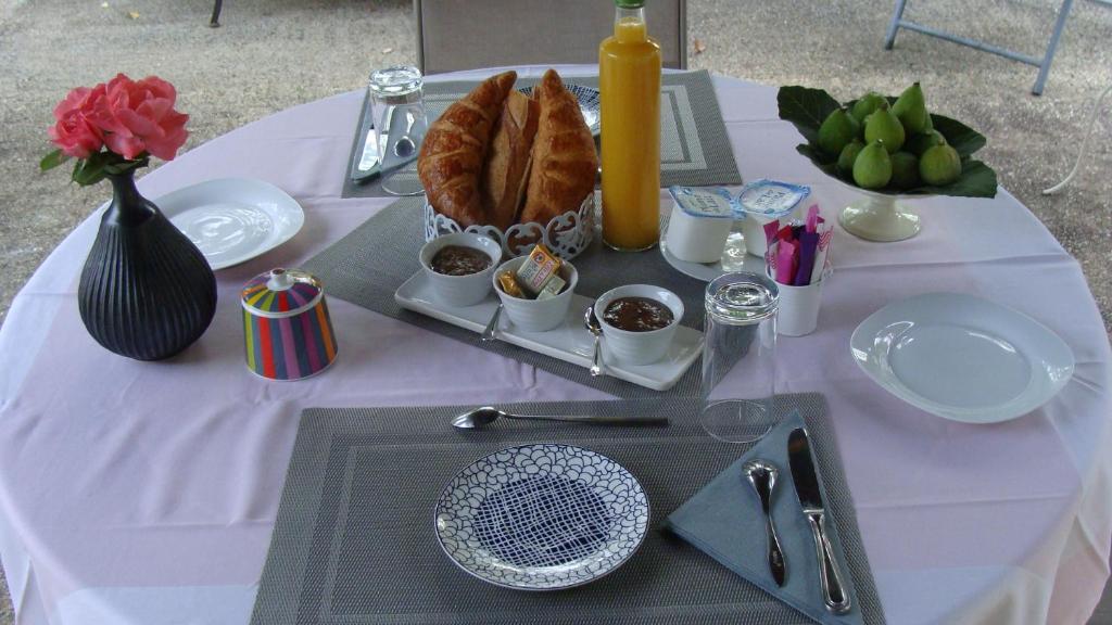 un tavolo con una tovaglia bianca e un piatto di cibo di Le Guinguetton Chambre d'hôtes a Prigonrieux