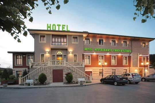 a hotel with cars parked in a parking lot at hotel gueñes in Güeñes