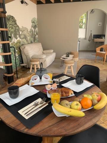 a wooden table with food and fruit on it at La Chapelle in Mamers