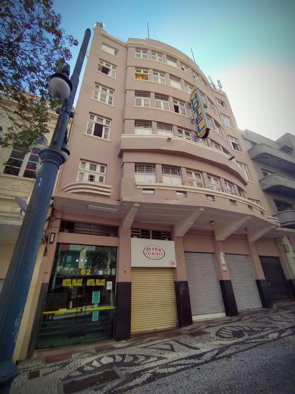 a large building with a store in front of it at Palace Hotel in Curitiba