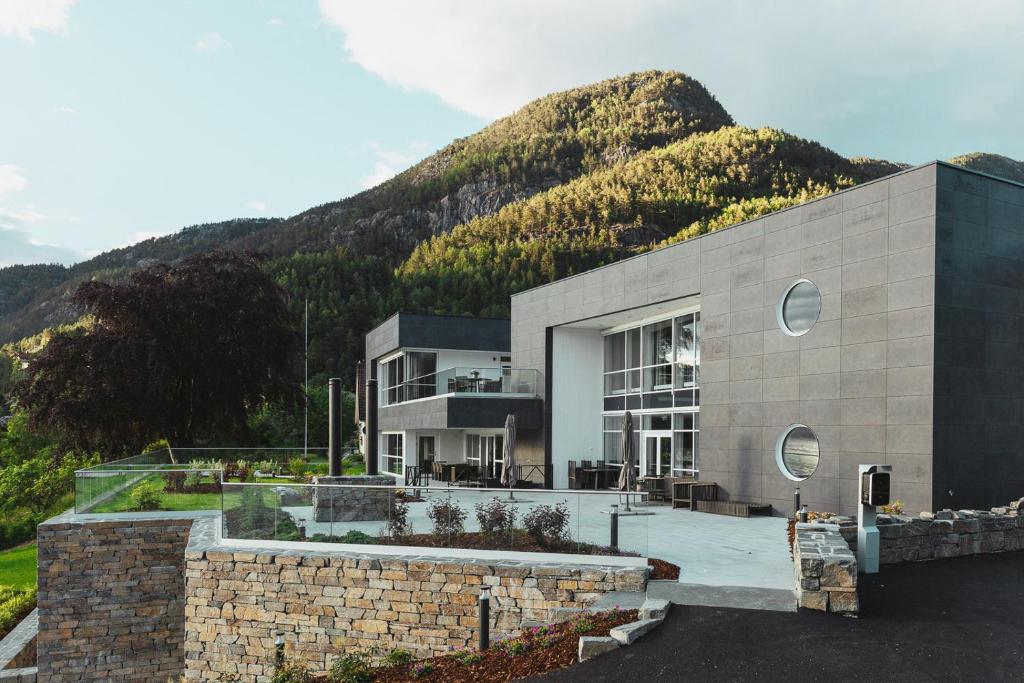 um grande edifício com uma montanha ao fundo em Hardanger House em Jondal